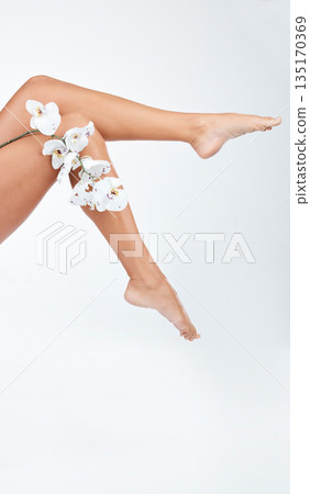 Woman, legs and body with flower, hair removal for skincare and wellness on white background. Female model, natural cosmetics and epilation with organic product for grooming and hygiene in studio Woman, legs and body with flower, hair removal for skincare and wellness on white background. Female model, natural cosmetics and epilation with organic product for grooming and hygiene in studio 135170369