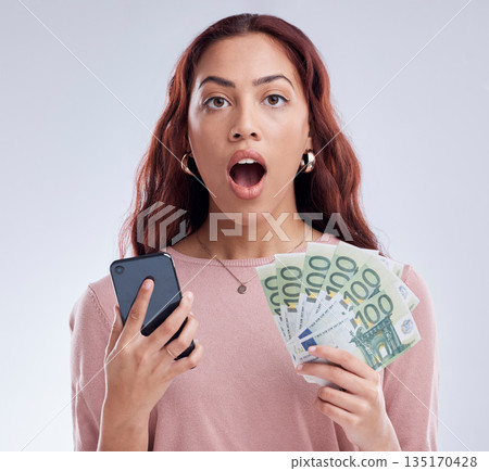 Investment, money or shocked woman with phone for online investment on digital fintech in studio. Financial mobile app, ecommerce payment or surprised girl typing banking data on internet with Euros 135170428