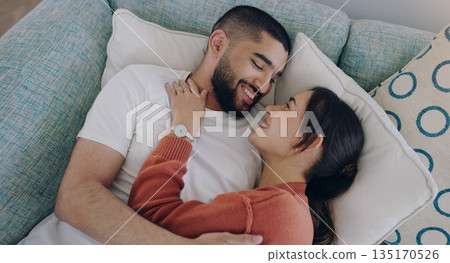 Top view of happy couple, love and hug on sofa in living room for romance, intimacy and relax together at home. Young man, woman and cuddle partner on couch for relationship, quality time and care 135170526