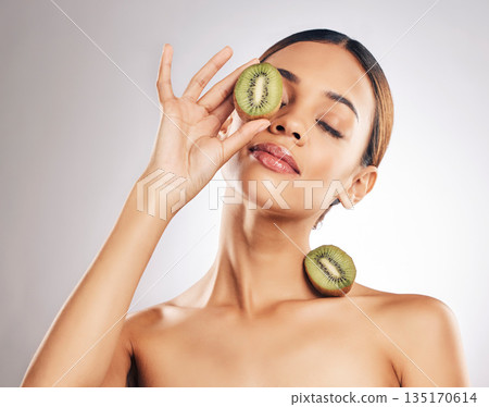 Skincare, kiwi and woman in studio for wellness, beauty or body care with natural cosmetic on grey background. Organic, treatment and female with fruit for vegan, eco or antioxidant, luxury or facial Skincare, kiwi and woman in studio for wellness, beauty or body care with natural cosmetic on grey background. Organic, treatment and female with fruit for vegan, eco or antioxidant, luxury or facial 135170614