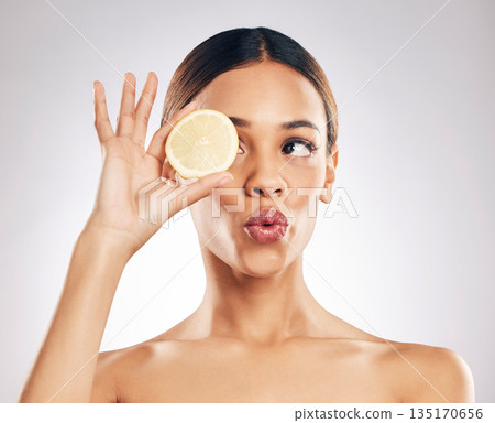 Woman, kiss face and lemon with beauty, skincare with organic cosmetic product isolated on studio background. Natural cosmetics, female model with pout and citrus fruit for skin glow with dermatology Woman, kiss face and lemon with beauty, skincare with organic cosmetic product isolated on studio background. Natural cosmetics, female model with pout and citrus fruit for skin glow with dermatology 135170656