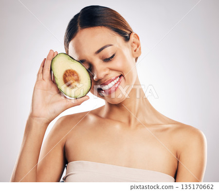 Happy, skincare and woman with avocado in studio for natural, cosmetics or facial on grey background. Smile, glow and girl model with fruit for vegan, environmental or skin detox with collagen Happy, skincare and woman with avocado in studio for natural, cosmetics or facial on grey background. Smile, glow and girl model with fruit for vegan, environmental or skin detox with collagen 135170662