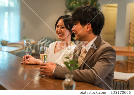 A couple in a dress code having a conversation while drinking champagne at a restaurant or bar 135170666