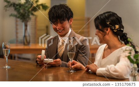 一名男子在酒吧櫃檯向一位毫不知情的女子突然求婚。 一名男子在酒吧櫃檯向一位毫不知情的女子突然求婚。 135170675