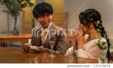 一名男子在酒吧櫃檯向一位毫不知情的女子突然求婚。 一名男子在酒吧櫃檯向一位毫不知情的女子突然求婚。 135170676