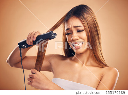 Woman with flat iron, haircare and heat damage, mistake and worried about hair loss on studio background. Electric straightener, female model with anxiety about keratin treatment fail and hairstyle 135170689