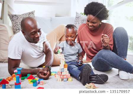 Building blocks, games and black family playing on a living room floor happy, love and bonding in their home. Child development, learning and kid with parents in lounge with alphabet, shape and toys Building blocks, games and black family playing on a living room floor happy, love and bonding in their home. Child development, learning and kid with parents in lounge with alphabet, shape and toys 135170957