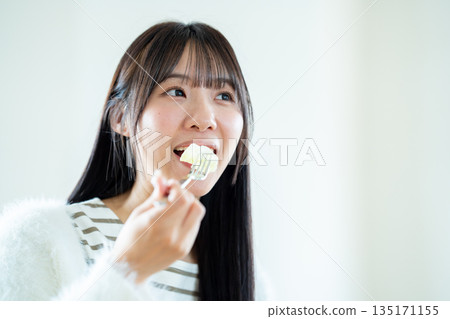一個年輕的女人做飯 135171155