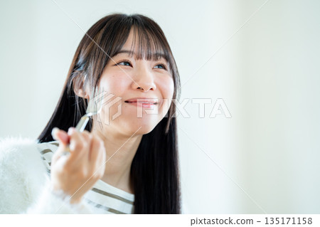 一個年輕的女人做飯 135171158