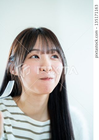 A young woman who makes a meal 135171163