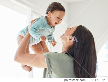 Mother holding laughing baby in home for love, care and quality time together to nurture childhood development. Happy mom, carrying and playing with infant girl kid for support, happiness and fun 135171194