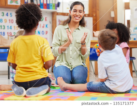 Diversity, teacher with children at school and playing together in a classroom at. Teaching or learning, education or collaboration and happy female person with preschool kids play on floor in class 135171377