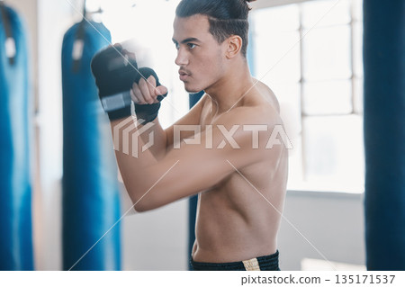 Sports, boxing and man punch for mma fight in gym for training, workout and martial arts exercise. Fitness, body builder and serious male athlete ready for boxer competition, practice and performance 135171537