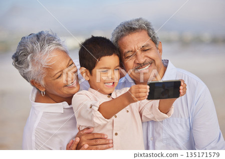 Selfie, smile and grandparents with child at beach for vacation, bonding and generations. Picture, happy and young boy with senior man and woman in nature for travel, happiness and technology 135171579
