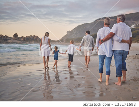 Family, generations and back with walking, beach and sunset with men, women and children with love. Parents, grandparents and kids by ocean, holding hands and bond on summer vacation with solidarity Family, generations and back with walking, beach and sunset with men, women and children with love. Parents, grandparents and kids by ocean, holding hands and bond on summer vacation with solidarity 135171698