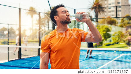Man, drinking water and fitness with padel, sports and hydration for wellness with exercise routine. Person, athlete and bottle for electrolytes, training or break at tennis court for game in city 135171867