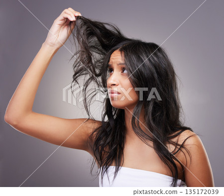 Frustrated, hair damage and woman with split ends on studio background for haircare, beauty and salon haircut. Girl, head and grooming problem or care, treatment and model with messy hairstyle Frustrated, hair damage and woman with split ends on studio background for haircare, beauty and salon haircut. Girl, head and grooming problem or care, treatment and model with messy hairstyle 135172039