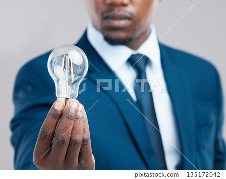 Energy, hand and businessman with light bulb for idea, knowledge or inspiration for corporate business strategy. Electricity, lightbulb and black man with creative solution, innovation or closeup Energy, hand and businessman with light bulb for idea, knowledge or inspiration for corporate business strategy. Electricity, lightbulb and black man with creative solution, innovation or closeup 135172042