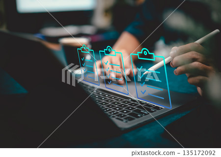 Digital checklists on laptop with virtual task management and person using stylus 135172092