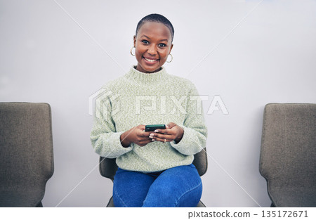 Black woman, phone and portrait on a chair in a waiting room with network connection for social media. African person happy for recruitment interview with a smartphone for internet, website or app Black woman, phone and portrait on a chair in a waiting room with network connection for social media. African person happy for recruitment interview with a smartphone for internet, website or app 135172671