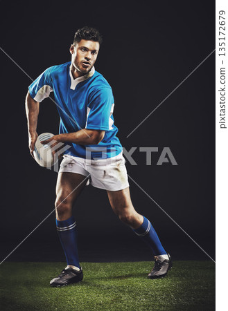Rugby, passing and man athlete running in dark studio background while training, wellness and fitness sport. Exercise, workout and professional career of sports male person or player on grass 135172679
