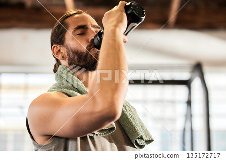 Tired, break and a man drinking water in the gym after training, hydrating and thirsty after a workout. Fitness, health and a hydrated person with a bottle to drink after sports, cardio or exercise Tired, break and a man drinking water in the gym after training, hydrating and thirsty after a workout. Fitness, health and a hydrated person with a bottle to drink after sports, cardio or exercise 135172717