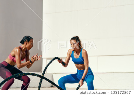 Woman, personal trainer and battle rope for exercise, workout or training in fitness outdoors. Active or serious coach with female person exercising with ropes for sports motivation on mockup space Woman, personal trainer and battle rope for exercise, workout or training in fitness outdoors. Active or serious coach with female person exercising with ropes for sports motivation on mockup space 135172867