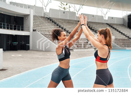 Happy woman, team and high five on stadium track for running, workout or exercise together in partnership. Sports women touching hands in support, fitness or friends for motivation, unity or training 135172884