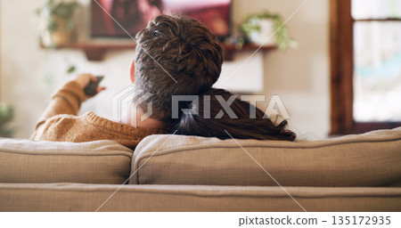 Watching tv, couple and love in a home on a living room sofa with bonding feeling relax. Cuddle, lounge couch and house with a television and movie with people back streaming series with remote Watching tv, couple and love in a home on a living room sofa with bonding feeling relax. Cuddle, lounge couch and house with a television and movie with people back streaming series with remote 135172935