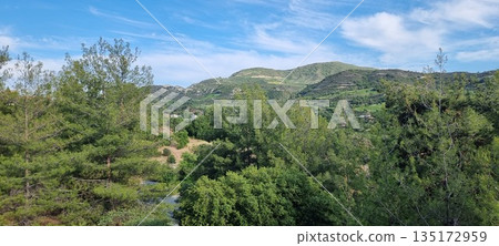 Lush green hills under blue sky Lush green hills under blue sky 135172959