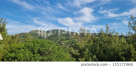 Lush green hills under blue sky Lush green hills under blue sky 135172968