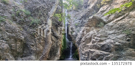 Narrow waterfall in rocky canyon Narrow waterfall in rocky canyon 135172978