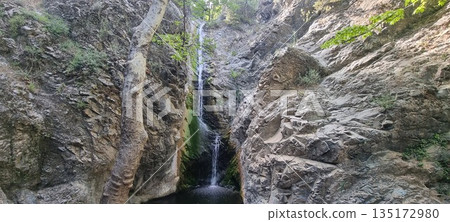 Narrow waterfall in rocky canyon Narrow waterfall in rocky canyon 135172980