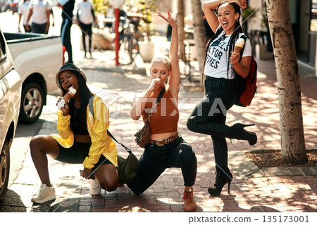Women friends, ice cream and street in city with edgy gen z fashion, comic pose or happiness on travel. Group, young woman and students with smile, gelato or dessert on summer vacation for crazy trip Women friends, ice cream and street in city with edgy gen z fashion, comic pose or happiness on travel. Group, young woman and students with smile, gelato or dessert on summer vacation for crazy trip 135173001