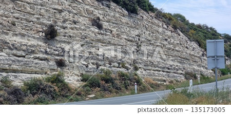 Mountain road curve with rocky cliff 135173005