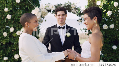 Love, holding hands and smile with lesbian couple at wedding for celebration, gay and pride. Lgbtq, spring and happiness with women at marriage event for partner commitment, care and freedom 135173020