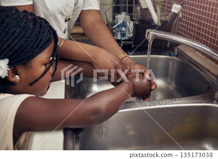 Hands, kitchen sink and mom with kid, teaching or help to wash with soap, water or clean to stop germs. African family home, mother and daughter at tap for cleaning, helping hand or wellness in house Hands, kitchen sink and mom with kid, teaching or help to wash with soap, water or clean to stop germs. African family home, mother and daughter at tap for cleaning, helping hand or wellness in house 135173038