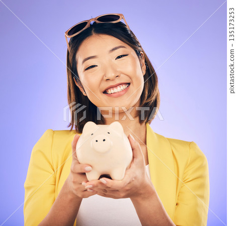 Piggy bank, saving and portrait of Asian woman in studio for investment, financial profit and budget. Finance, banking and face of happy female person with money container for savings, cash and coins 135173253