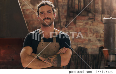 Portrait, industry and a man arms crossed in a workshop for metal work, engineering or construction. Manufacturing, production and a confident young male industrial blacksmith in a factory or plant Portrait, industry and a man arms crossed in a workshop for metal work, engineering or construction. Manufacturing, production and a confident young male industrial blacksmith in a factory or plant 135173480