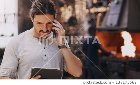 Hammer, anvil and fire with men working in a forge for metal work manufacturing or production. Industry, welding and trade with blacksmith professionals in a workshop, plant or industrial foundry 135173562