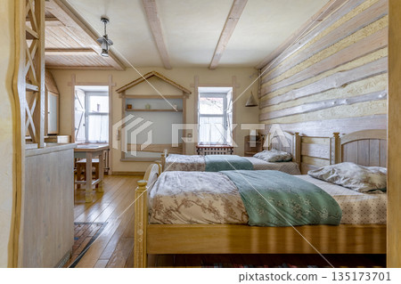 Rustic studio apartment interior with twin beds and wooden decor Rustic studio apartment interior with twin beds and wooden decor 135173701