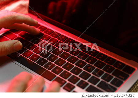 Working on a neon computer keyboard with colored backlighting. Computer video games, hacking, technology, internet concept. Selected focus. Working on a neon computer keyboard with colored backlighting. Computer video games, hacking, technology, internet concept. Selected focus. 135174325
