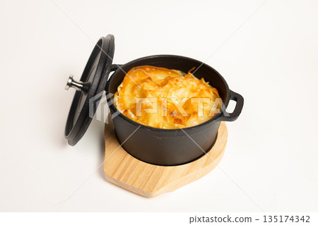 Close-up of baked dish in cast iron skillet - appetizing meal on white background 135174342