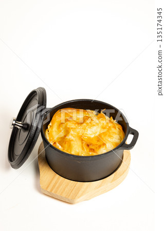 Close-up of baked dish in cast iron skillet - appetizing meal on white background Close-up of baked dish in cast iron skillet - appetizing meal on white background 135174345