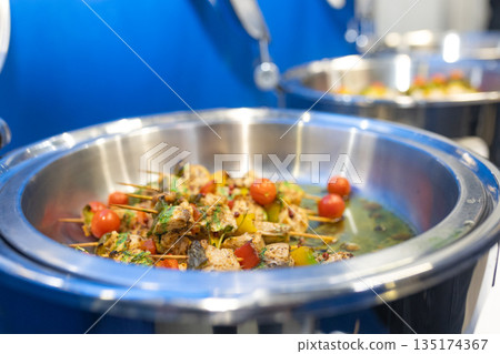 Close-up of chicken skewers with vegetables in metal bowl, details of texture and presentation Close-up of chicken skewers with vegetables in metal bowl, details of texture and presentation 135174367