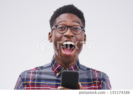 Black man, surprise and phone for winning, prize or good news against a white studio background. Shocked or surprised African male person on mobile smartphone of winner in wow for lottery competition Black man, surprise and phone for winning, prize or good news against a white studio background. Shocked or surprised African male person on mobile smartphone of winner in wow for lottery competition 135174386