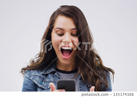 Woman, surprise and phone for winning, prize or good news against a white studio background. Shocked, surprised or excited female person reading on mobile smartphone of lottery winner in wow or bonus Woman, surprise and phone for winning, prize or good news against a white studio background. Shocked, surprised or excited female person reading on mobile smartphone of lottery winner in wow or bonus 135174388