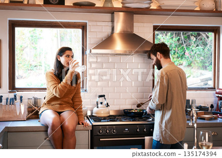 Cooking, couple and wine in a kitchen at home with food at a stove drinking alcohol. Young woman, man and drinks in a house together making dinner with bonding, love and care for eating a meal Cooking, couple and wine in a kitchen at home with food at a stove drinking alcohol. Young woman, man and drinks in a house together making dinner with bonding, love and care for eating a meal 135174394