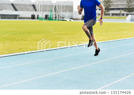 Man, legs and running on track for fitness, workout or exercise of athlete training at the stadium. Leg of male person or runner exercising in run, athletics or sports competition for healthy cardio Man, legs and running on track for fitness, workout or exercise of athlete training at the stadium. Leg of male person or runner exercising in run, athletics or sports competition for healthy cardio 135174426