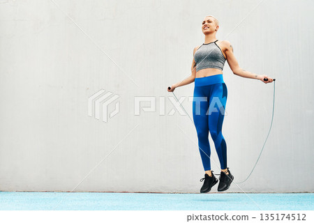 Jump, rope and woman skipping against space in stadium for sports, workout practice and cardio. Performance, health and body with female athlete training on track for strong, mockup and exercise 135174512